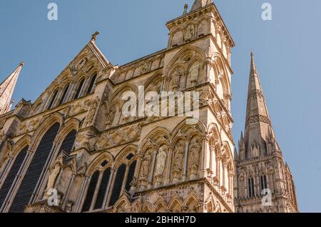 Salisbury Cathedral looking up at the Great West front with the spire in the background on a clear, sunny spring day Stock Photo