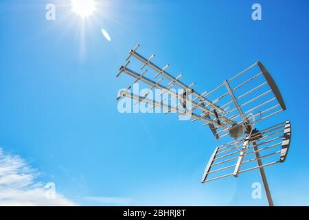 Television antenna on a rooftop against a clear sunny blue sky Stock Photo