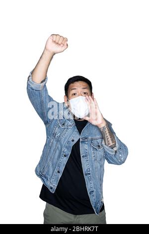 Bearded asian men worker dressed in jeans with medical mask is feeling serious raising fist up in white background.The concept of protest, attention, Stock Photo