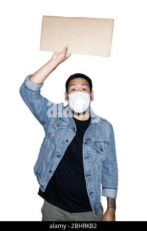 Bearded asian men worker dressed in jeans with medical mask is holding cardboard in white background.The concept of protest, attention, request. Place Stock Photo