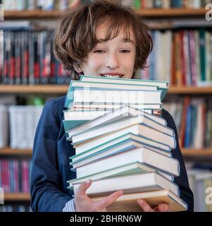 Learning at home, online learning, self quarantine concept. Children doing homework with books, textbooks and with computer online Stock Photo