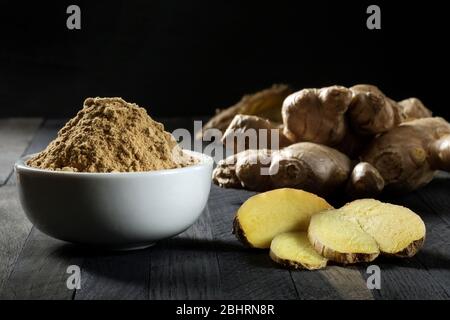 Ground ginger root in a bowl on a wooden table. Stock Photo