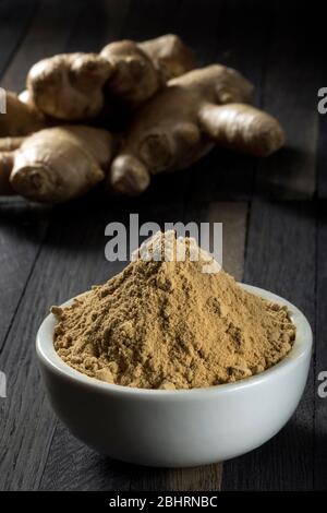 Ground ginger root in a bowl on a wooden table. Stock Photo