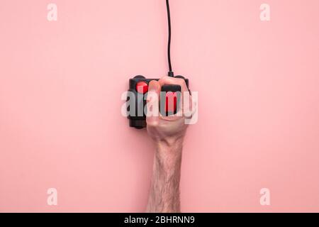 Male hand using retro video game joystick controller. Overhead view Stock Photo