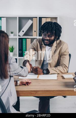 Cropped view of african american recruiter shaking hands with employee at job interview in office Stock Photo