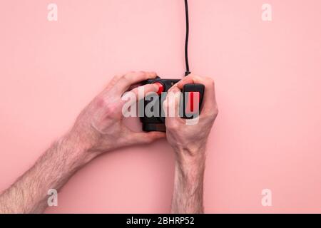 Male hand using retro video game joystick controller. Overhead view Stock Photo