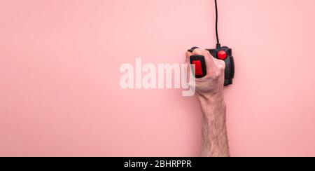 Male hand using retro video game joystick controller. Overhead view Stock Photo