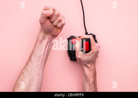 Male hand using retro video game joystick controller. Overhead view Stock Photo