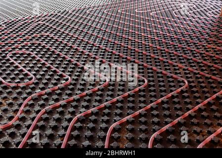 Underfloor heating system installation. Close up on water floor heating system interior of a new residential building. Pipes filled with propylene Stock Photo