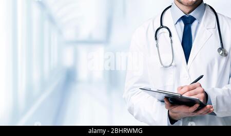 Quality Medical Services. Unrecognizable Doctor In Uniform Taking Notes To Clipboard Stock Photo