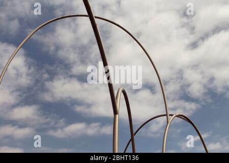 View of gigantic, modern sculpture with cloudy blue sky background in Barcelona port. It is named Waves (Onades) by Andreu Alfaro. It is a sunny summe Stock Photo