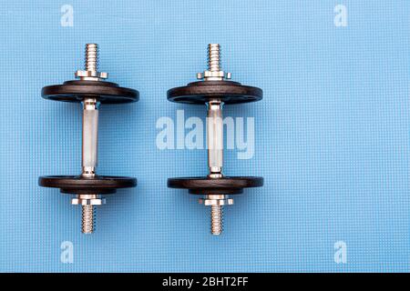 Two iron dumbbells on blue mat, concept sport picture Stock Photo