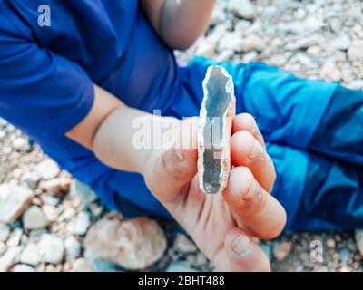 Child holding a piece of silex found on a field trip with his hand Stock Photo