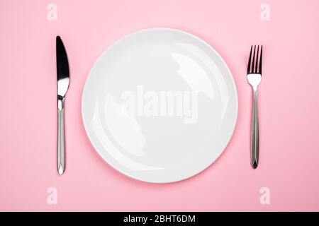 Cutlery on a pink background. Copyspace in the plate.  Stock Photo