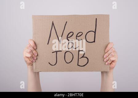 Need a job concept. Cropped close up photo of hands arms showing carton poster with text looking for vacancy isolated grey background Stock Photo