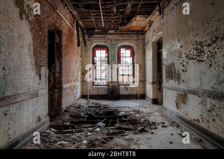 Stained glass windows in the hallway of an historic Abandoned Hospital Stock Photo