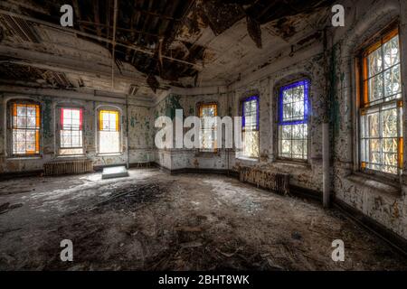 Stained glass windows in the common area of an historic Abandoned Hospital Stock Photo