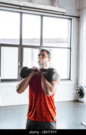 athletic sportsman exercising with heavy dumbbells Stock Photo