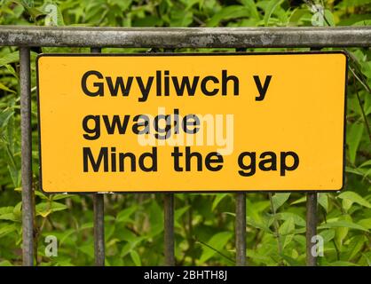 Close up view of a bilingual 'Mind the Gap' sign on a railway station platform Stock Photo