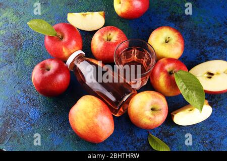Apple cider drink and apples with leaves on rustic table Stock Photo