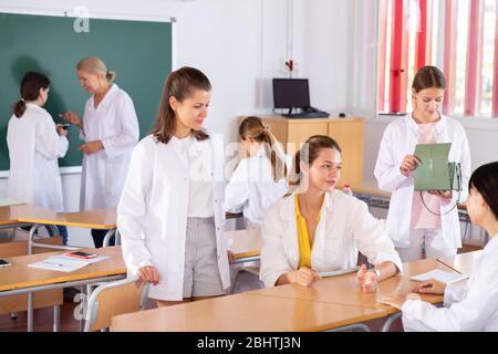 Medical students talking and having fun, spending time together during recess between lectures in auditorium Stock Photo