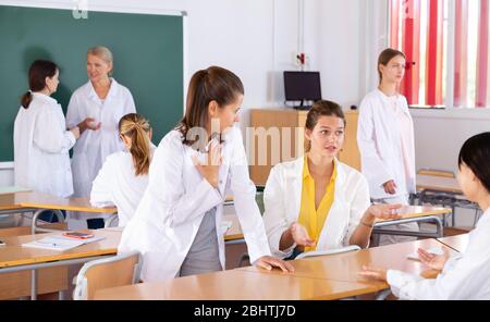 Medical students talking and having fun, spending time together during recess between lectures in auditorium Stock Photo