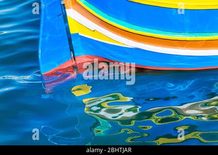 Reflections of stern of luzzo traditional fishing boat, Marsaxlokk, Malta