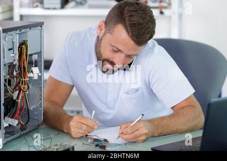 angry customer trying to repair computer with phone support Stock Photo