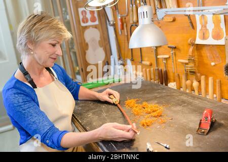 female luthier working on the creation of a violin Stock Photo