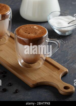 Tasty homemade Dalgona coffee in glass cup with ingredients, milk and suger. Recipe popular Korean drink latte with foam of instant coffee. Created ne Stock Photo