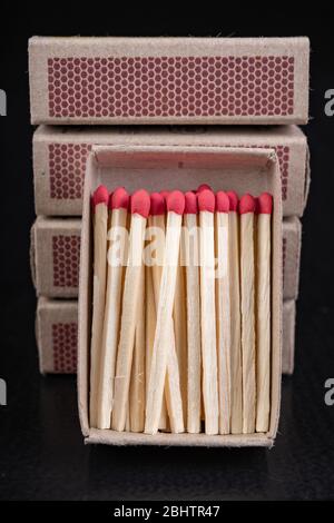 Matches for resurrecting fire in gray boxes. Old methods of lighting a fire. Dark background. Stock Photo