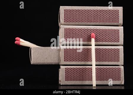 Matches for resurrecting fire in gray boxes. Old methods of lighting a fire. Dark background. Stock Photo