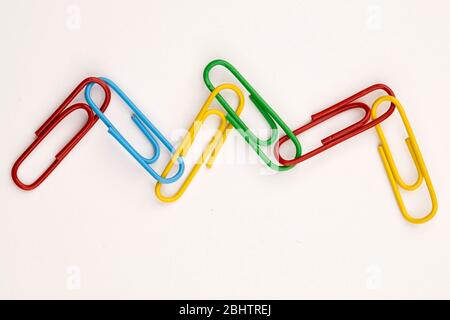 A concept photo of a wavy link of multi-colored paperclips. Stock Photo