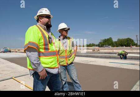 Austin Texas USA, April 6, 2011: Construction supervisor watches over crew working on concrete highway. ©Marjorie Kamys Cotera/Daemmrich Photography Stock Photo