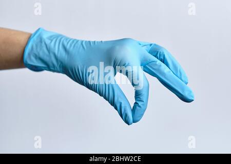 A hand in medical gloves abstractly holds something. Close up. Stock Photo