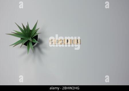 The word Gospel written in wooden letter tiles on a white background.  Concept religion, worship, and church. Stock Photo