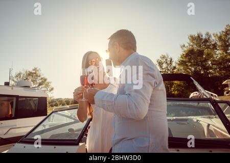 Couple in a river boat or yacht toasting with sparkling wine Stock Photo