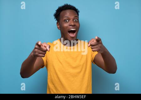 Cheerful attractive african man pointing on you making a choice. Stock Photo