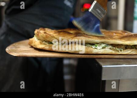 Brushing olive oil on flatbread pizza in Rome Stock Photo