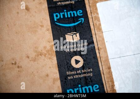 Lyon, France - Aug 7, 2019: Close-up macro view of wet Amazon Prime parcel cardboard with multiple water drops being delivered under rainy weather Stock Photo