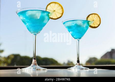 blue lagoon cocktail in martini glass garnished with lemon Stock Photo