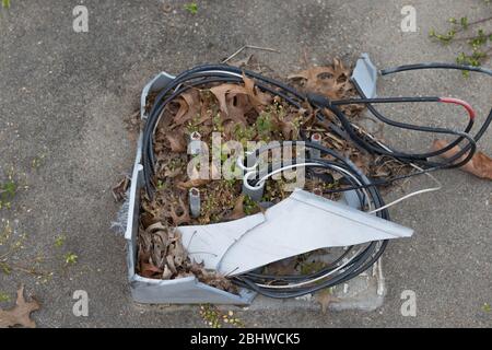 Newport News, VA/USA-March 16, 2020: Remnants of light post in an abandoned neighborhood with exposed wires and broken plastic. Stock Photo