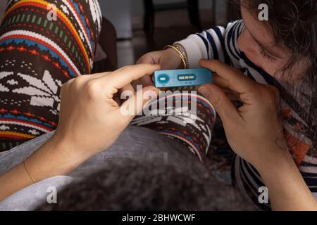 Young woman with her little girl looking pregnancy test result at home Stock Photo