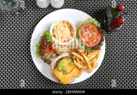 Open Burger plate served with coleslaw and french fries Stock Photo