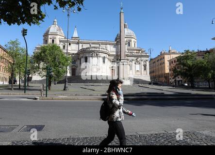 (200428) -- ROME, April 28, 2020 (Xinhua) -- A woman wearing a face mask and gloves walks along a street in Rome, Italy, on April 27, 2020. The total number of infections, fatalities and recoveries in Italy stood at 199,414, which is 1,739 higher than the caseload on Sunday. The downward trend in new infections detected since last week continued on Monday. The number of COVID-19 patients in serious and critical conditions also kept declining, with 1,956 people currently in intensive care, down by 53 compared to Sunday, and 20,353 people hospitalized, down by 1,019. (Xinhua/Cheng Tingting) Stock Photo