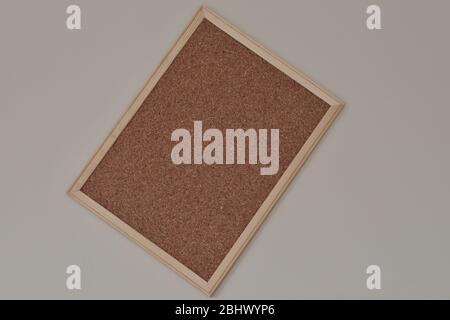 Cork board hanging on the wall with wooden frame. Stock Photo