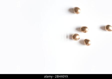 A few small golden eggs. White background. Stock Photo
