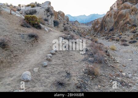 Mount Whitney looms in the mist from the Mobius Arch Trail in the Alabama Hills near Lone Pine, California, USA