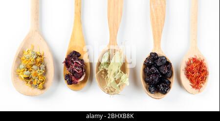 Collection of tea and natural additives in wooden spoons, isolated on white Stock Photo