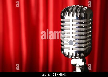 Retro silver microphone on red fabric background Stock Photo